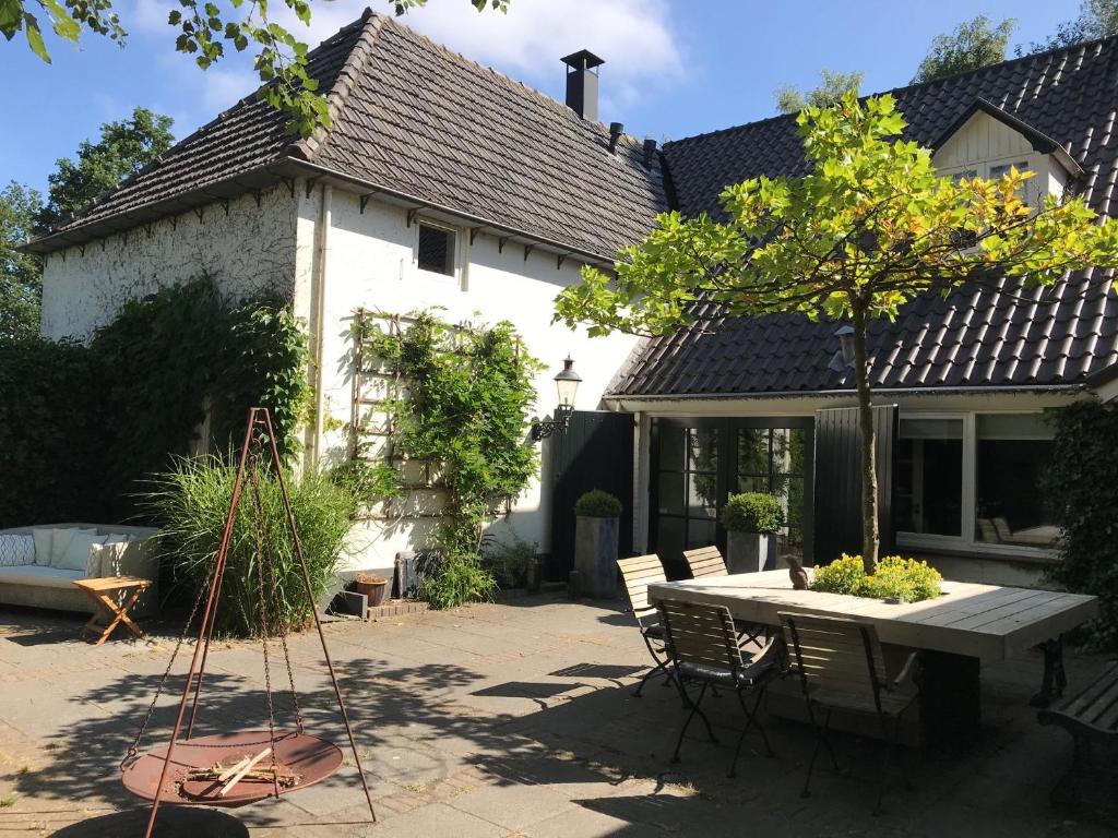 een huis met een tafel en stoelen in de tuin bij B&B Het Wellnest in Hulshorst