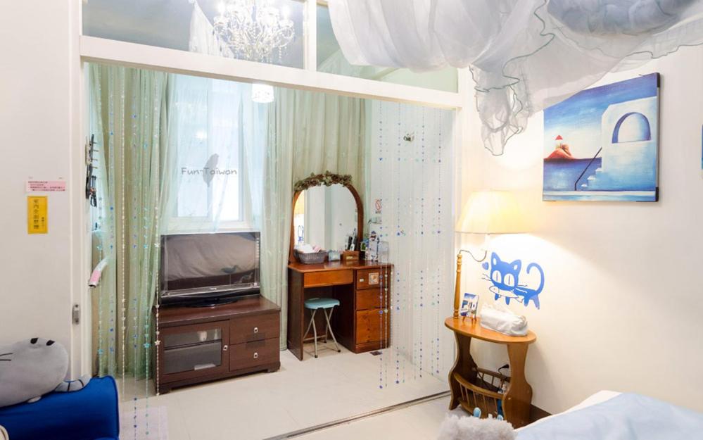 a bedroom with a bed and a desk and a mirror at sweet home B&amp;B in Hualien City