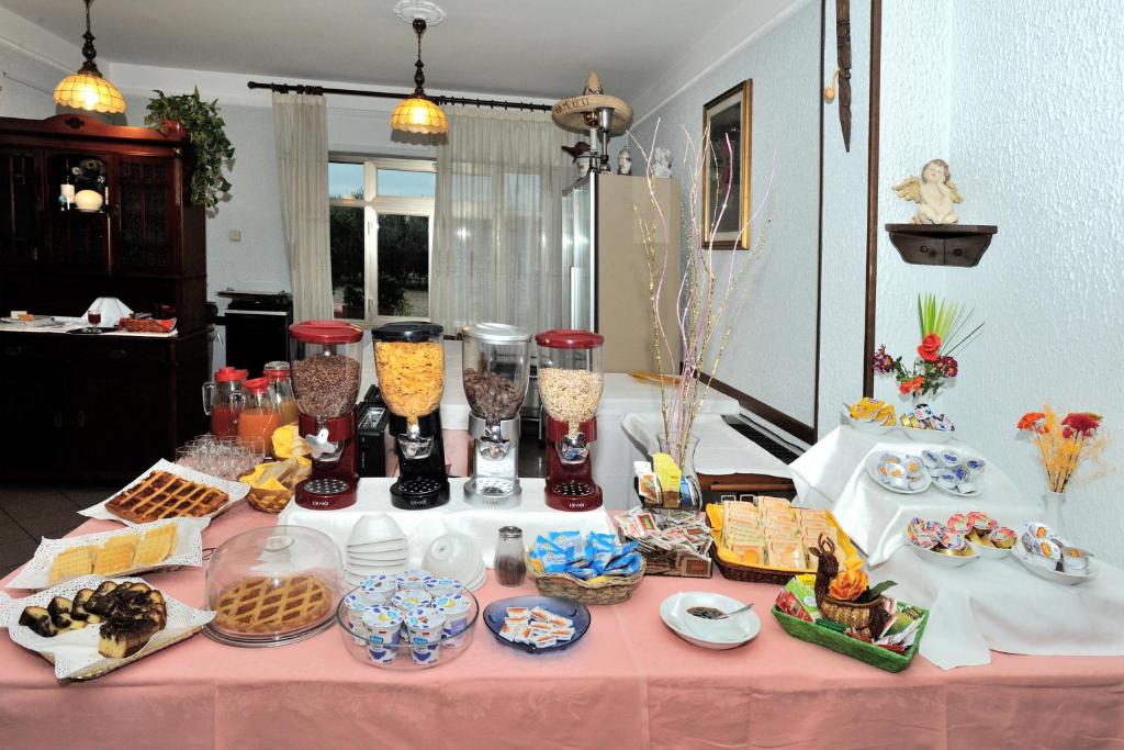 a table with a pink table cloth with food and vases at Hotel Lidia in Alba Adriatica