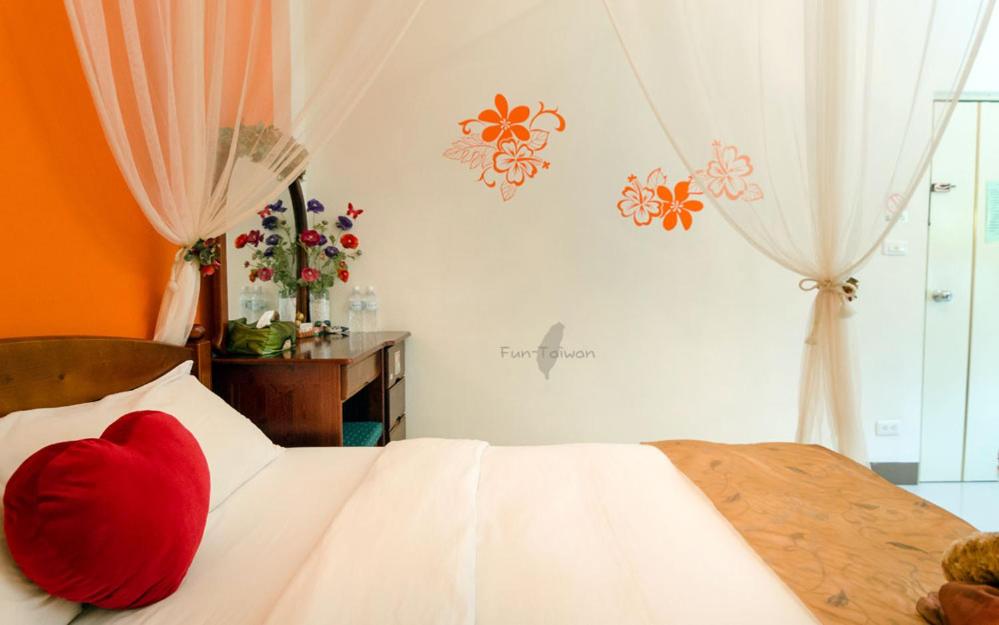 a red heart pillow on a bed in a bedroom at sweet home B&amp;B in Hualien City