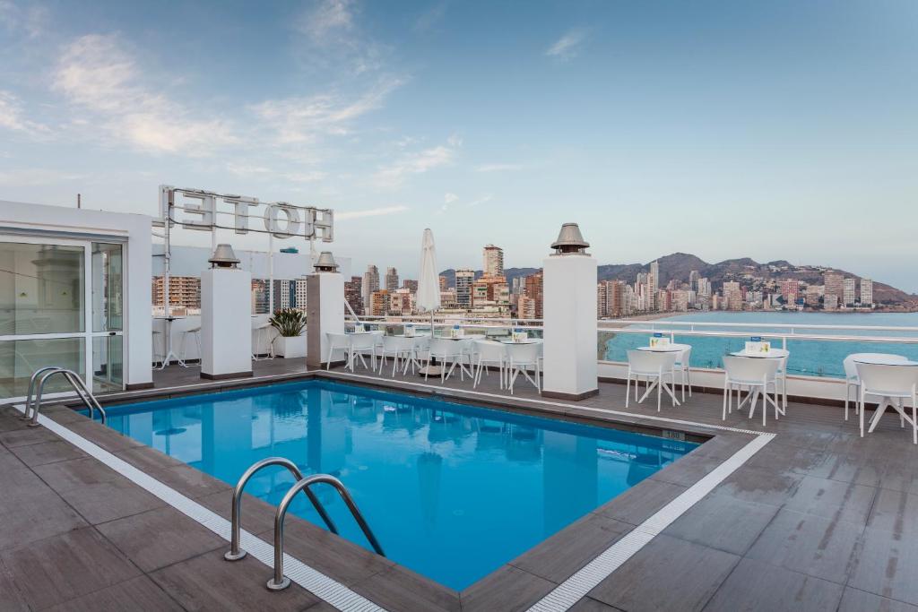 a pool on the roof of a building with a view at Hotel Centro Mar in Benidorm