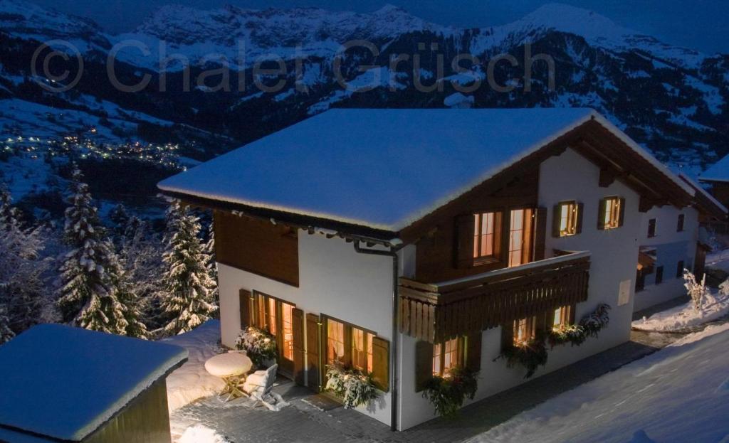 a house covered in snow at night with a mountain at Chalet Grüsch in Grüsch