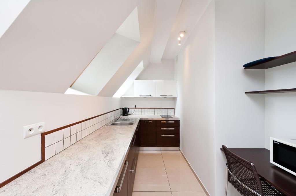 an attic kitchen with white walls and a counter at Apartamenty Sun & Snow Centrum in Zakopane