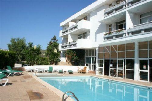 a large building with a swimming pool in front of it at Apartamentos Martha's in Palmanova