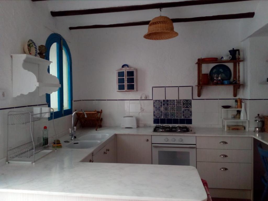 een keuken met een wastafel en een fornuis top oven bij Tranquil Spanish Mountain Retreat in Benirrama