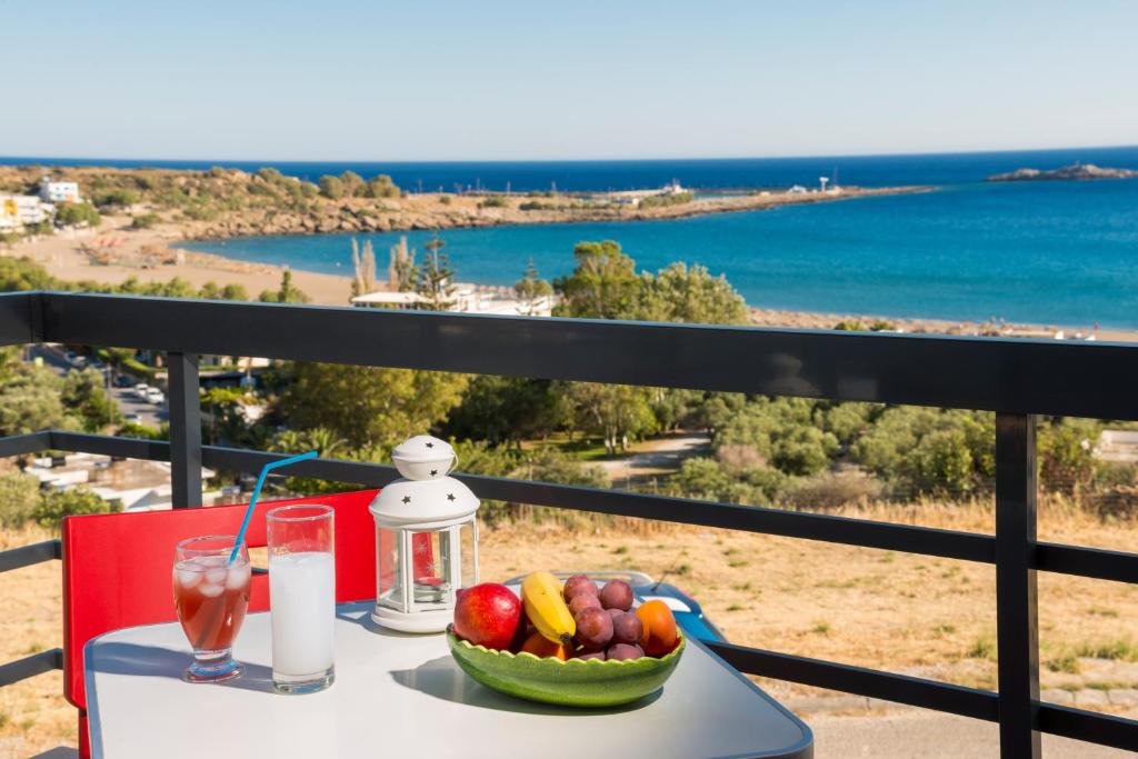una mesa con un bol de fruta y una bebida en Caravella Luxury Apartments, en Palaiochóra