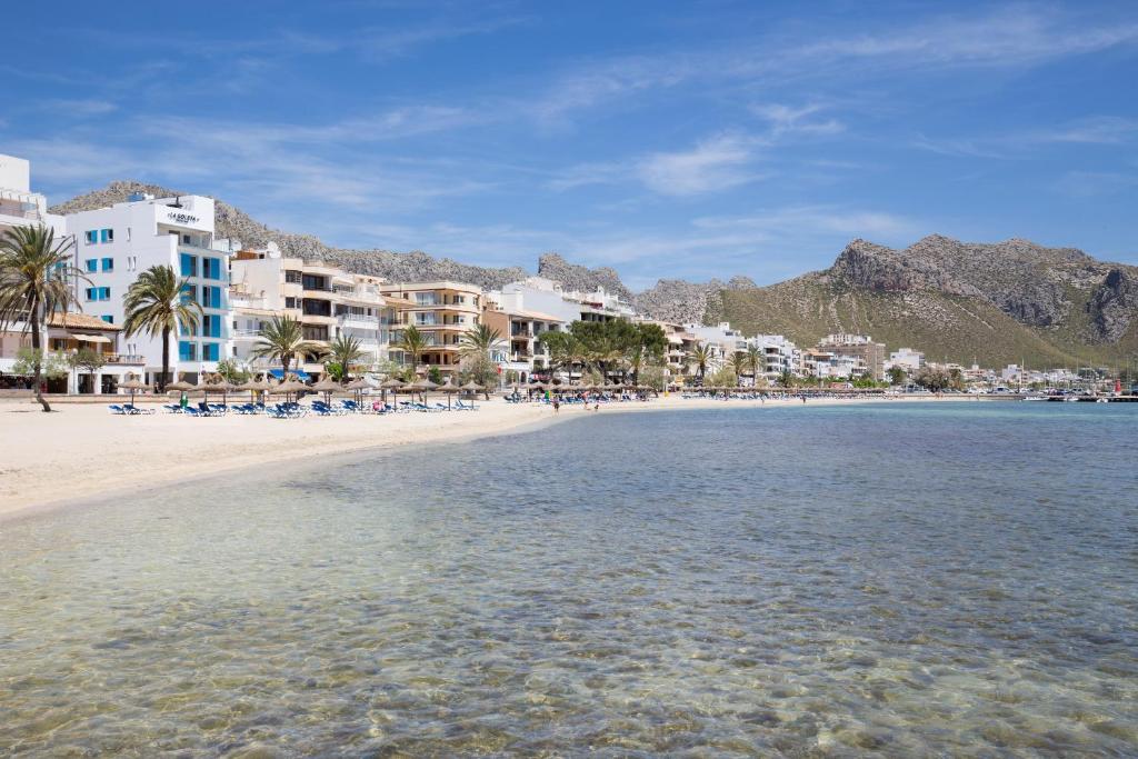 een uitzicht op een strand met gebouwen en het water bij La Goleta Hotel de Mar - Adults Only in Port de Pollença