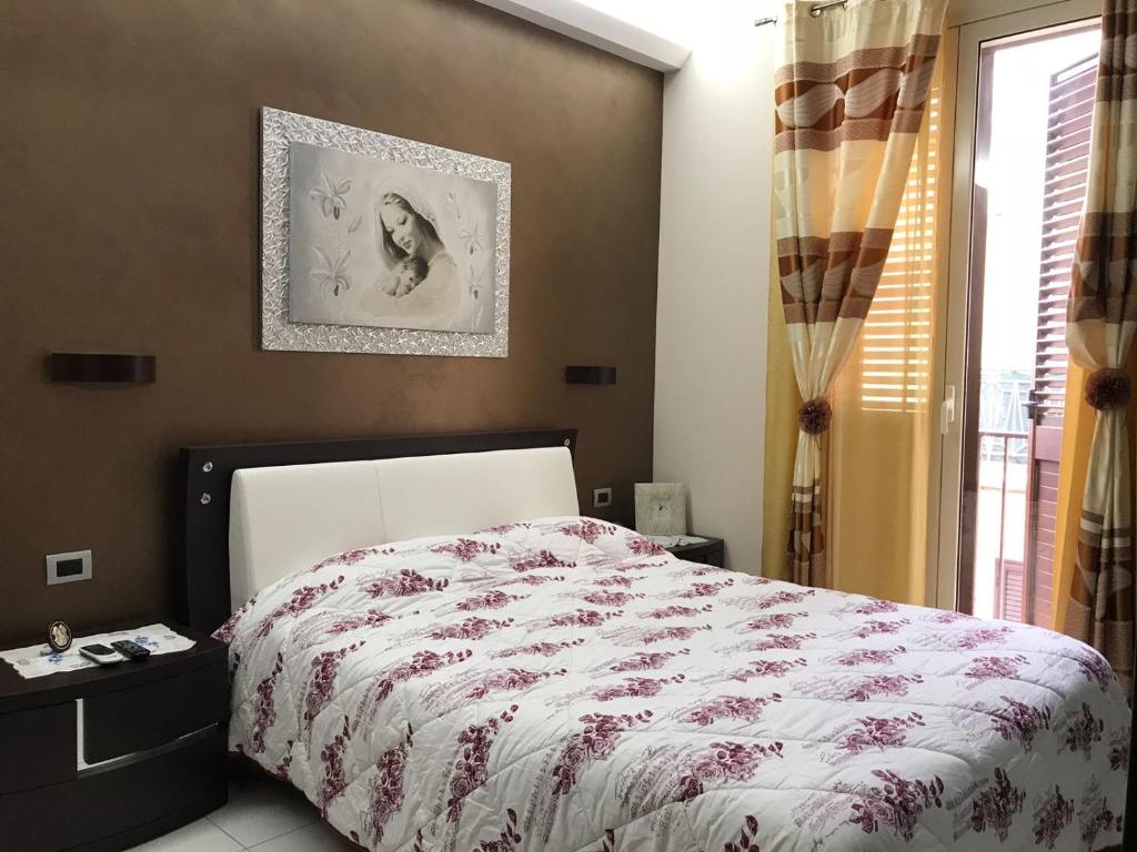a bedroom with a bed with a red and white comforter at Casa Angela in Avola