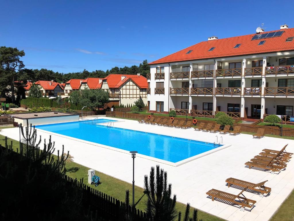 a large swimming pool in front of a building at Apartament Plaza 7 - Rezydencja Nadmorska Rogowo in Rogowo