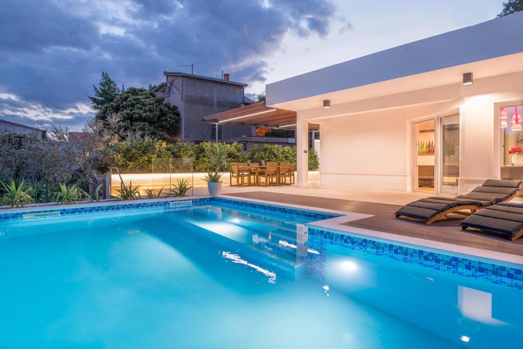 a swimming pool in front of a house at Luxury apartment Shelena in Mravince