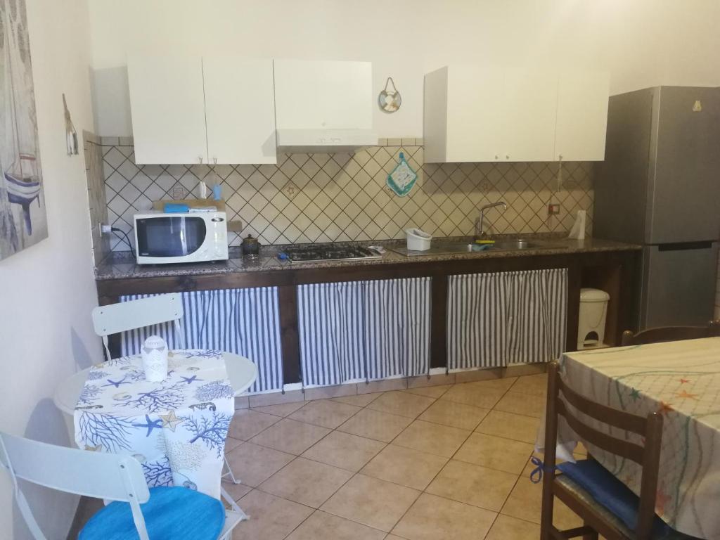 uma pequena cozinha com uma mesa e um micro-ondas em Mandriola Putzuidu Capo Mannu em Putzu Idu