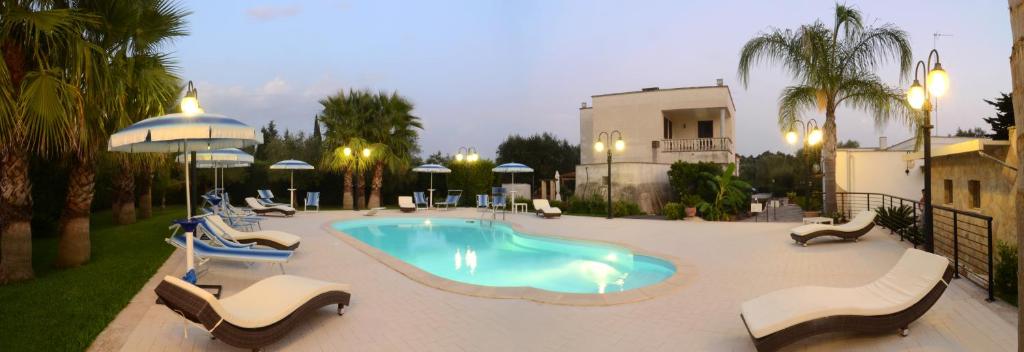 une piscine avec des chaises longues et une piscine dans l'établissement B&B Villa Vittoria, à Maglie