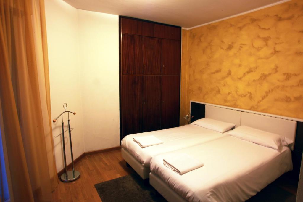 De La Tour في تيرانو: غرفة نوم مع سرير مع وسادتين بيضاء
