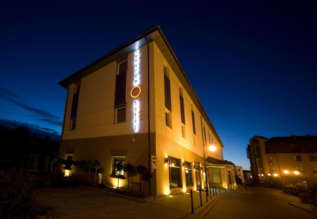 a building with a sign on the side of it at night at Hotel Centrum in Kwidzyn