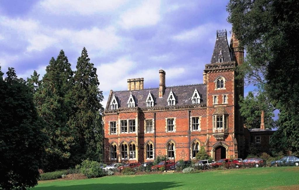 a large red brick building with a tower at Brownsover Hall in Rugby