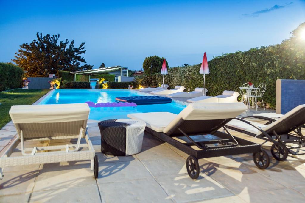 a pool with a group of chairs and a swimming pool at Casa Vacanze Un Tuffo Nel Blu in Matera