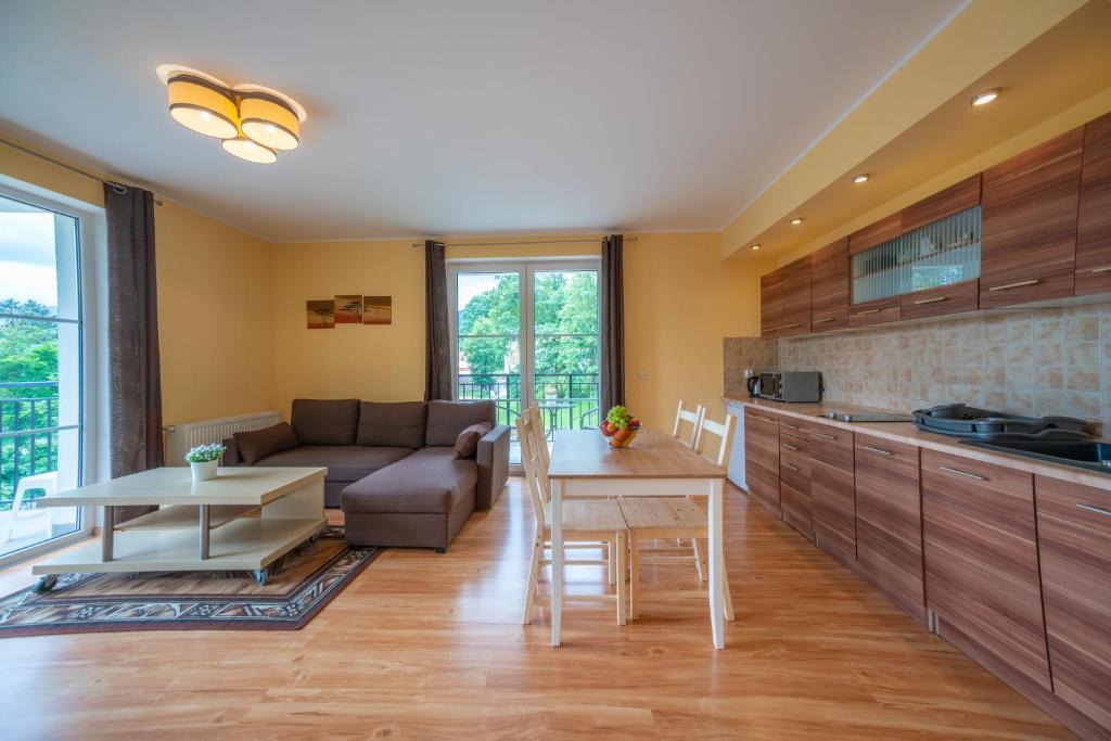 a kitchen and living room with a couch and a table at RentPlanet - Apartamenty Mickiewicza in Szklarska Poręba