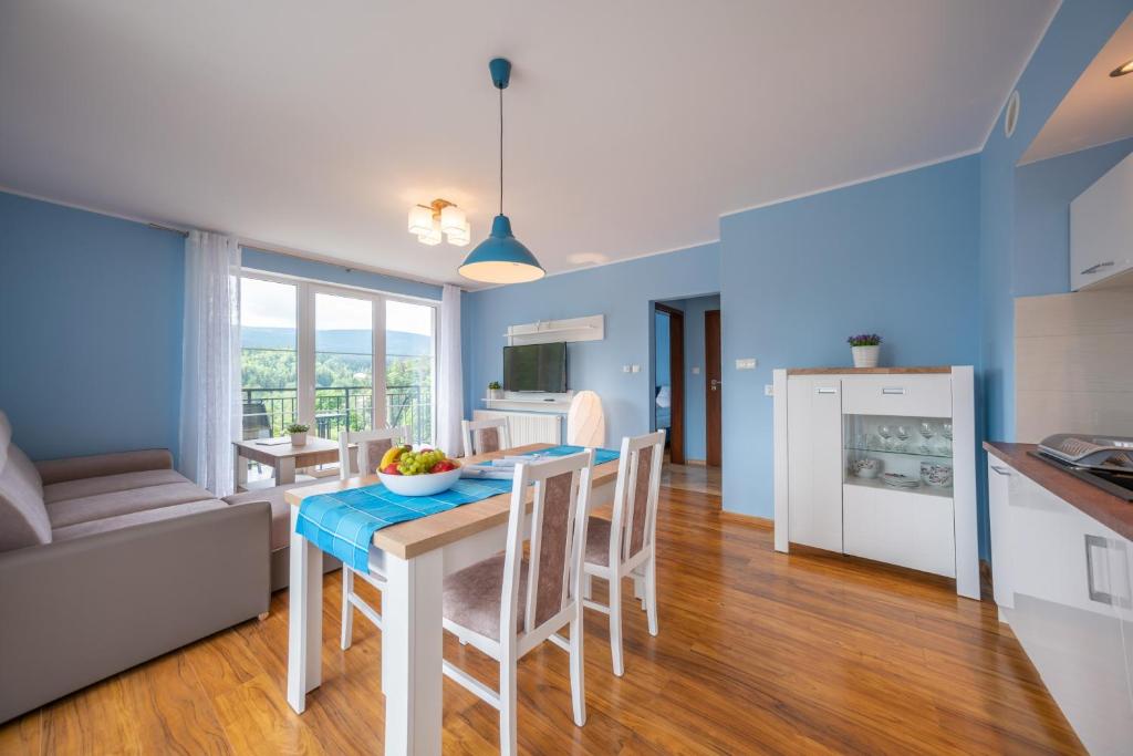a kitchen and dining room with a table and chairs at RentPlanet- Apartamenty Poezja - Dworcowa in Szklarska Poręba