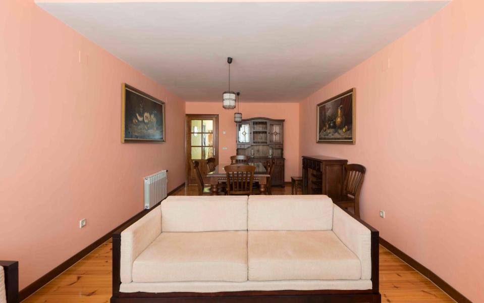 ein Wohnzimmer mit einem weißen Sofa und einem Tisch in der Unterkunft Vivienda de Uso Turístico La Atalaya in El Barco de Ávila