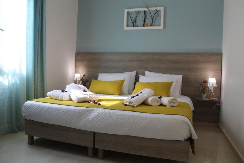 een slaapkamer met een groot bed en handdoeken bij Myron Suite Old Town in Rethimnon
