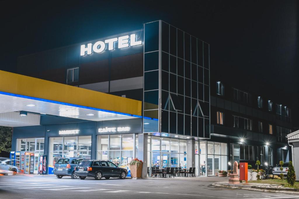 un hotel con coches aparcados fuera de él por la noche en Hotel Brcko Gas Prijedor, en Prijedor