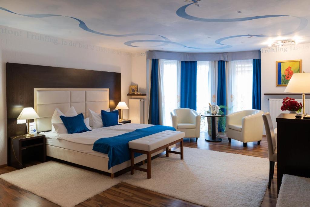 a bedroom with a large bed with a blue ceiling at Hotel Central in Bad Mergentheim