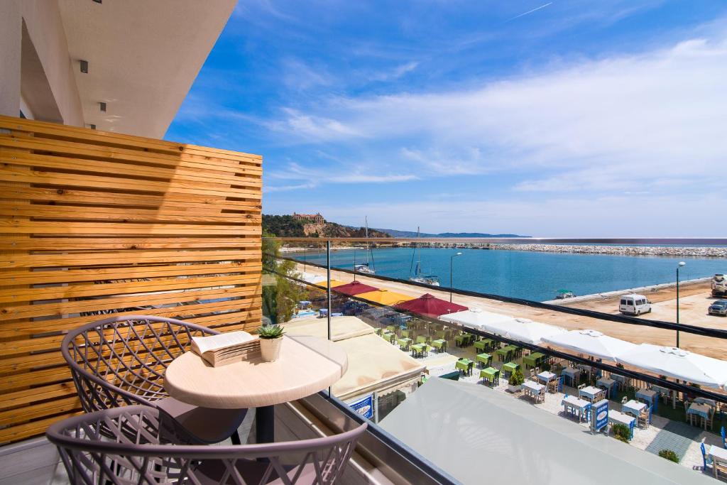 balcón con mesa y vistas al océano en Molos Hotel en Limenaria