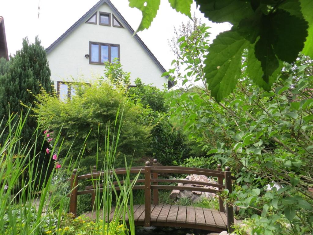 un jardín con un banco frente a una casa en Ferienwohnung "Waldblick" en Bad Liebenstein