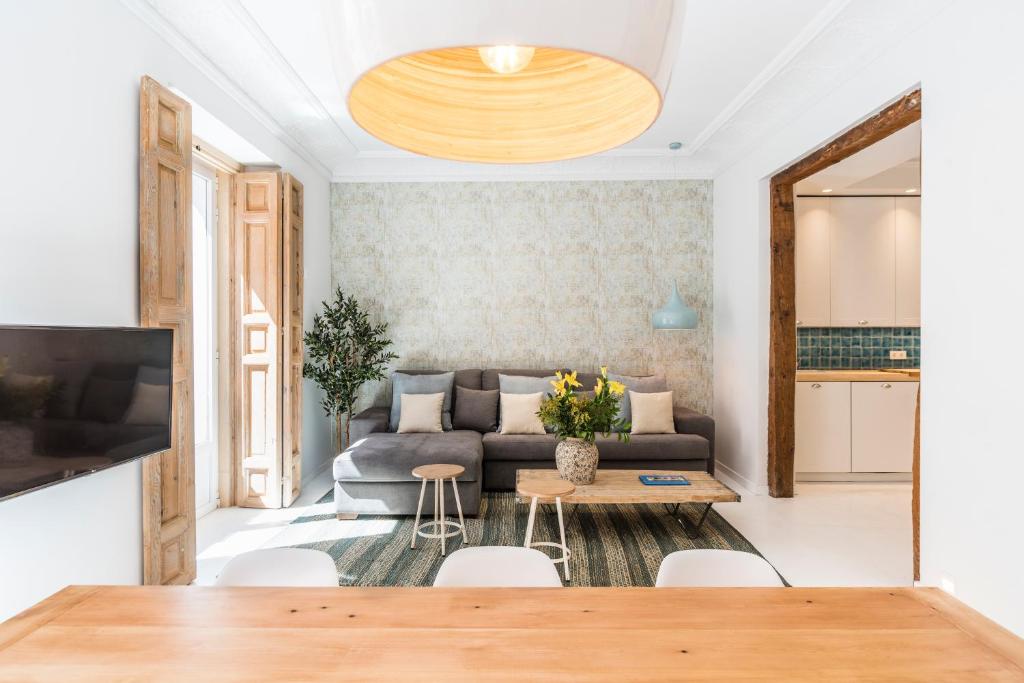 ein Wohnzimmer mit einem Sofa und einem Tisch in der Unterkunft BNBHolder Group Stunning SOL in Madrid