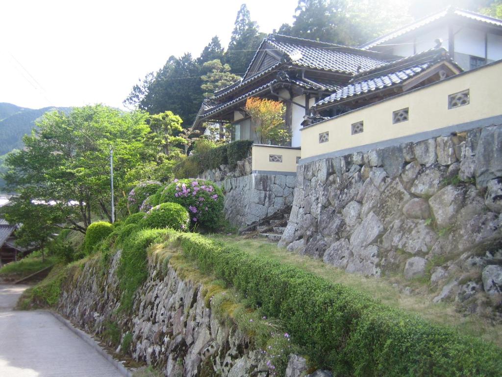 eine steinerne Mauer neben einem Haus in der Unterkunft Japanese Style Inn Dohzen Miwa in Niimi