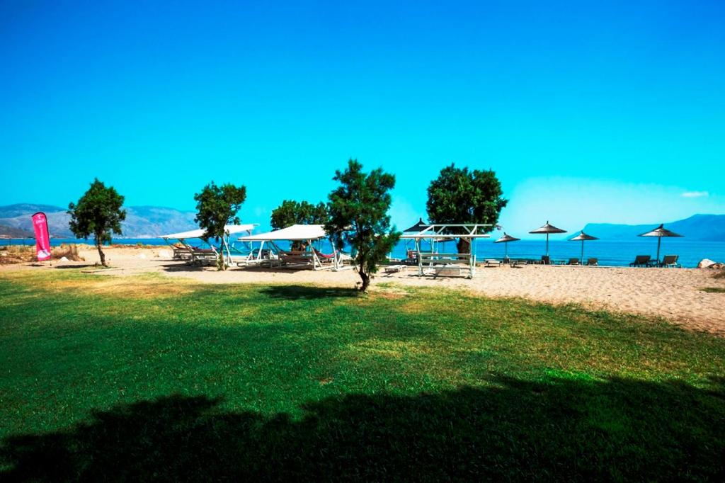 a beach with umbrellas and chairs and the ocean at Naya in Kissamos