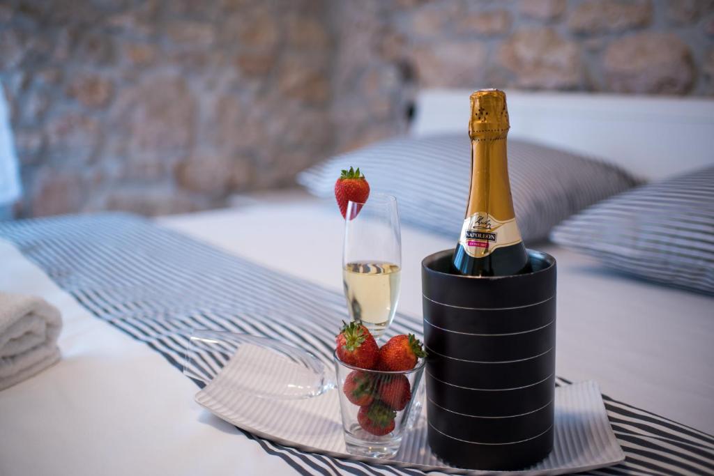 a bottle of champagne and strawberries on a table at Apartments Tara in Vrbnik