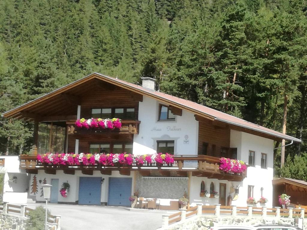 une maison avec des fleurs sur le balcon dans l'établissement Haus Falkner, à Niederthai