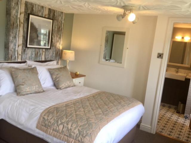 A bed or beds in a room at The Swan Inn