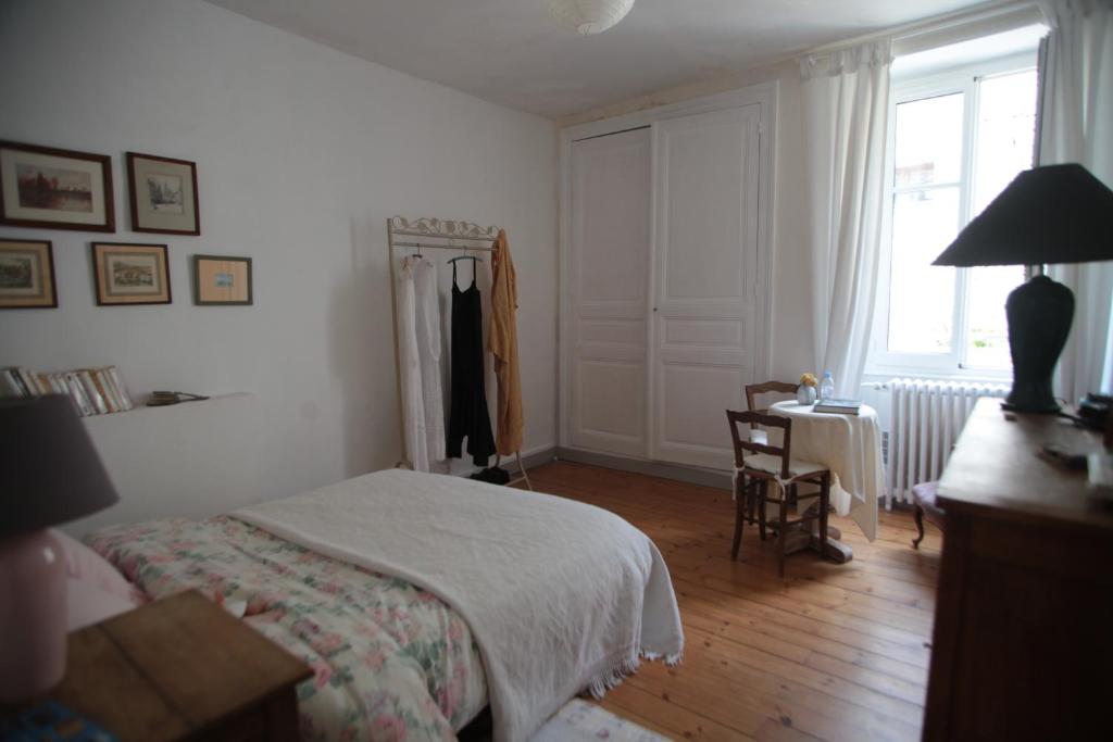 a bedroom with a bed and a desk and a window at Le Magnolia in La Rochefoucauld
