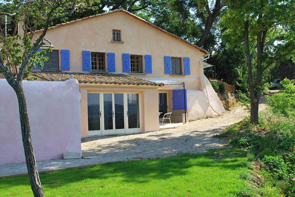 ein Haus mit blauen Fensterläden und einem Hof in der Unterkunft Olivier in Mazan