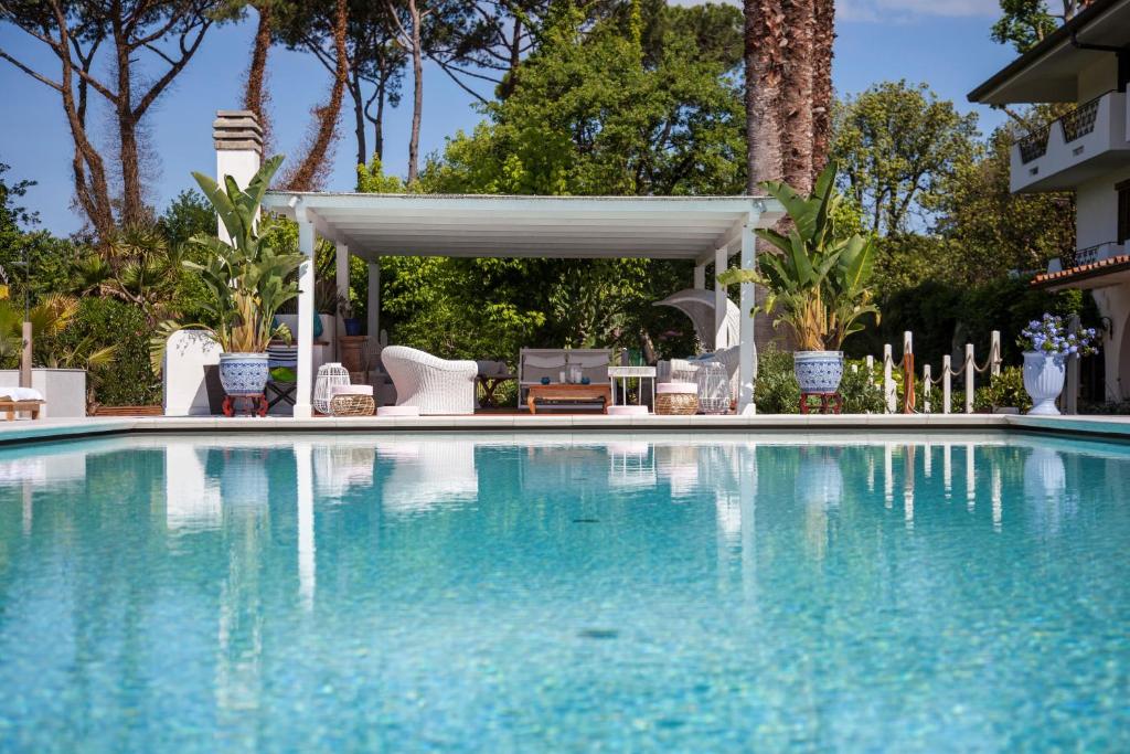 a swimming pool with a gazebo next to a house at California Park Hotel in Forte dei Marmi