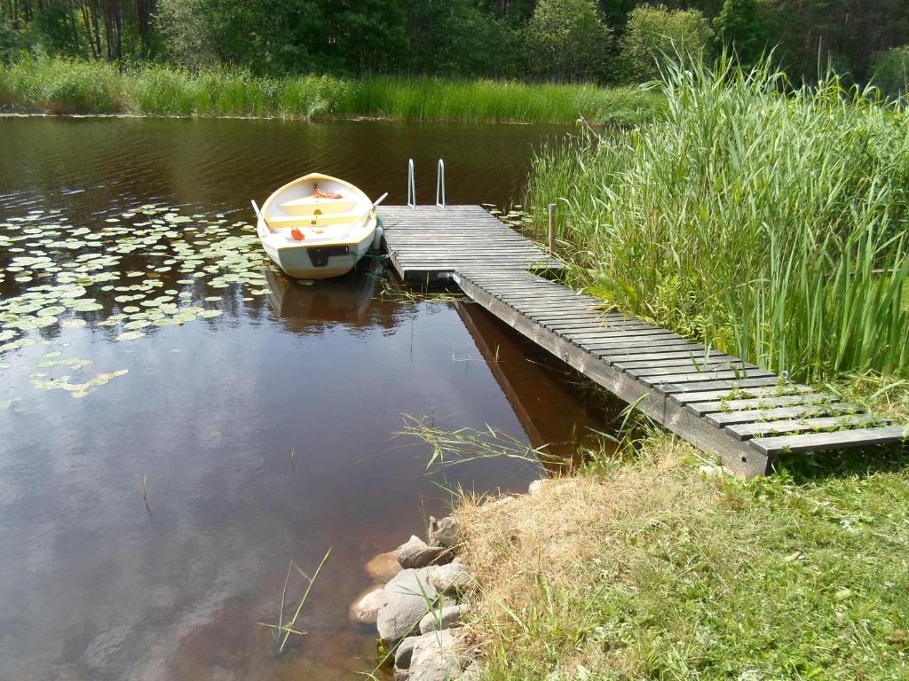 a small boat sitting next to a dock in the water at Tihase puhkemajake in Pärnu