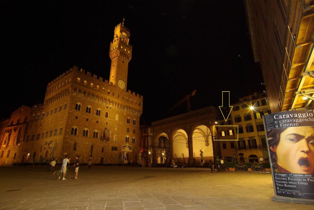 a large building with a clock tower at night at Piazza Signoria 1, apartment in Florence