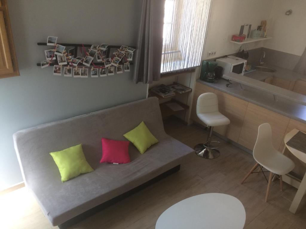 sala de estar con sofá y 2 almohadas coloridas en Guitte family en Poilly-sur-Serein