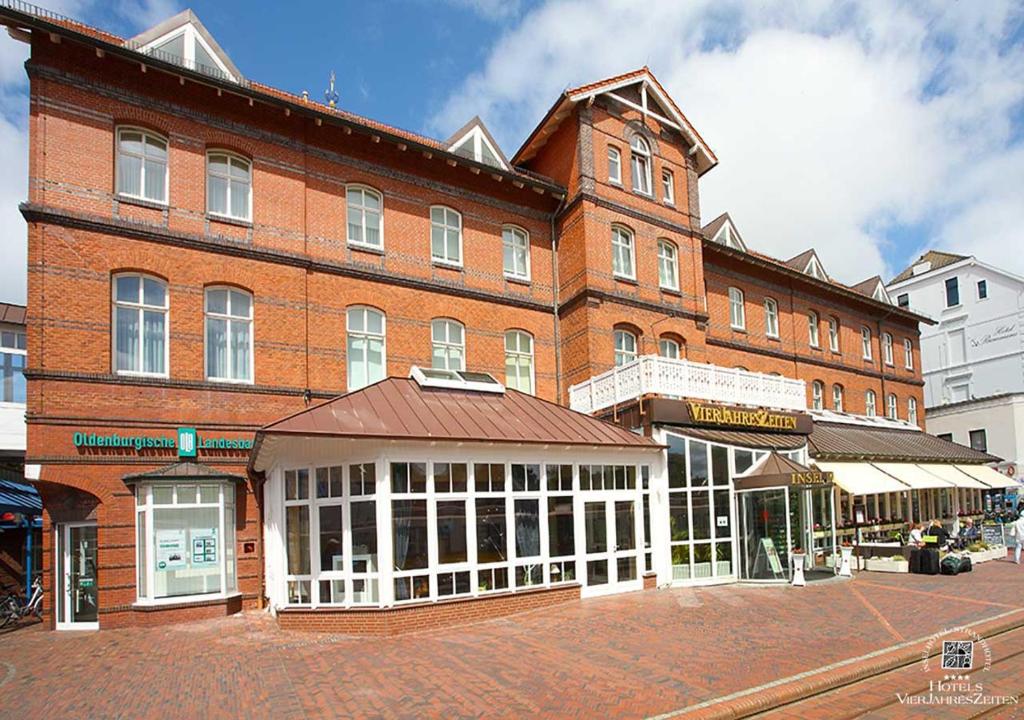 a large brick building on a city street at Inselhotel VierJahreszeiten in Borkum