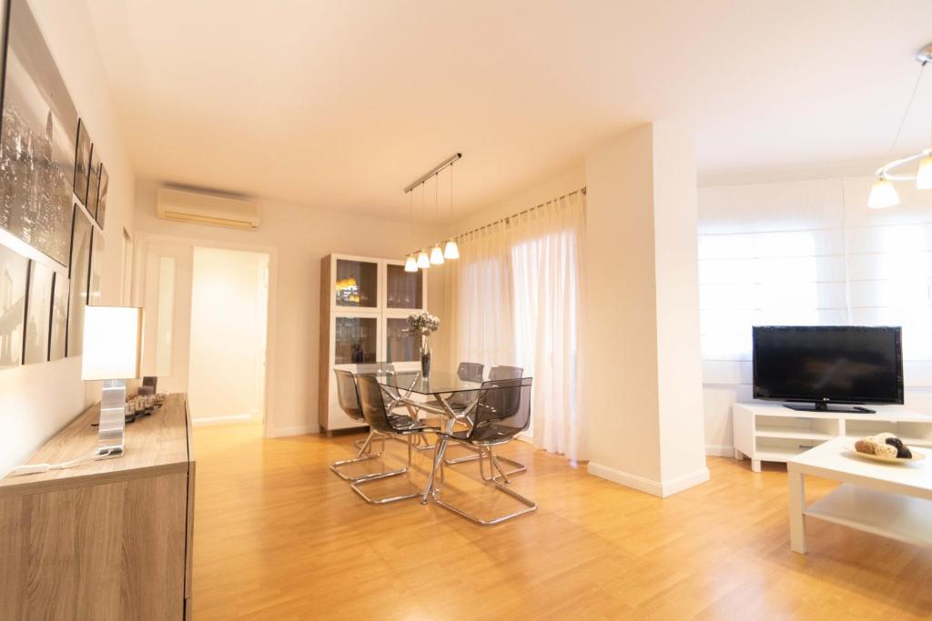 a living room with a table and chairs and a television at Alquileres Kakiko in Sanlúcar de Barrameda