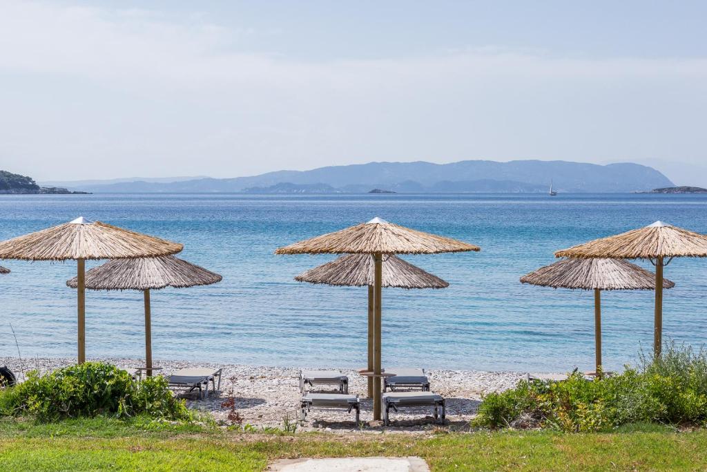 a group of chairs and umbrellas on a beach at Milia Beach Apartments in Paralia Milia