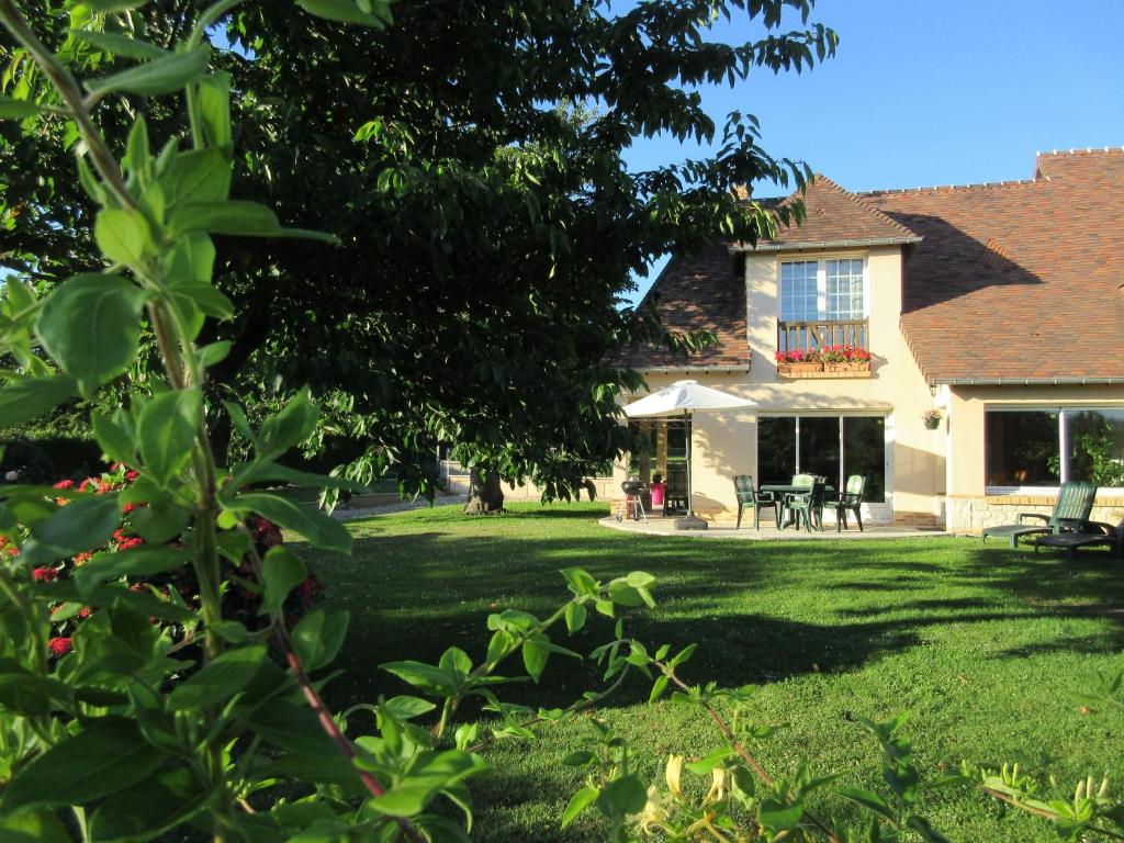 una casa con un patio con césped verde en Gite De La Balle De Golf en Jumièges