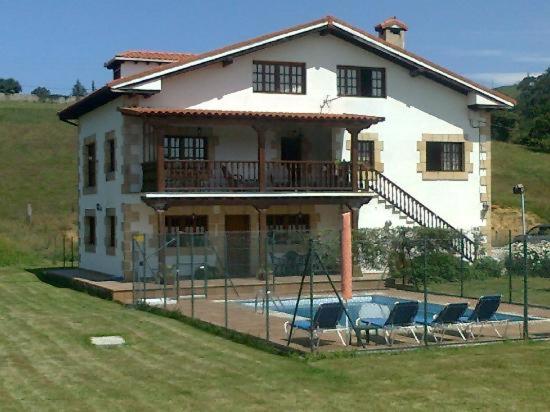 una casa grande con piscina frente a ella en Posada Adela en Santillana del Mar