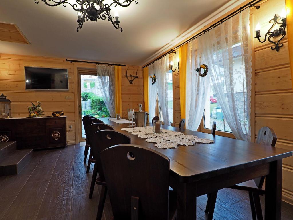 Willa u Kubusia في زاكوباني: غرفة طعام مع طاولة وكراسي خشبية طويلة