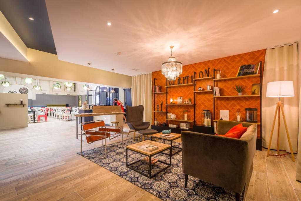 ein Wohnzimmer mit einem Sofa, Stühlen und einem Tisch in der Unterkunft The Originals Boutique, Hôtel Le Londres, Saumur (Qualys-Hotel) in Saumur