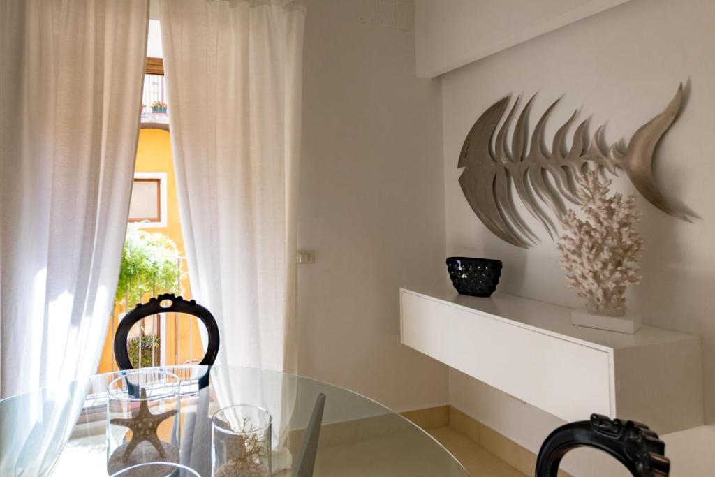 a dining room with a glass table and a bird sculpture on the wall at etnart gallery house in Catania