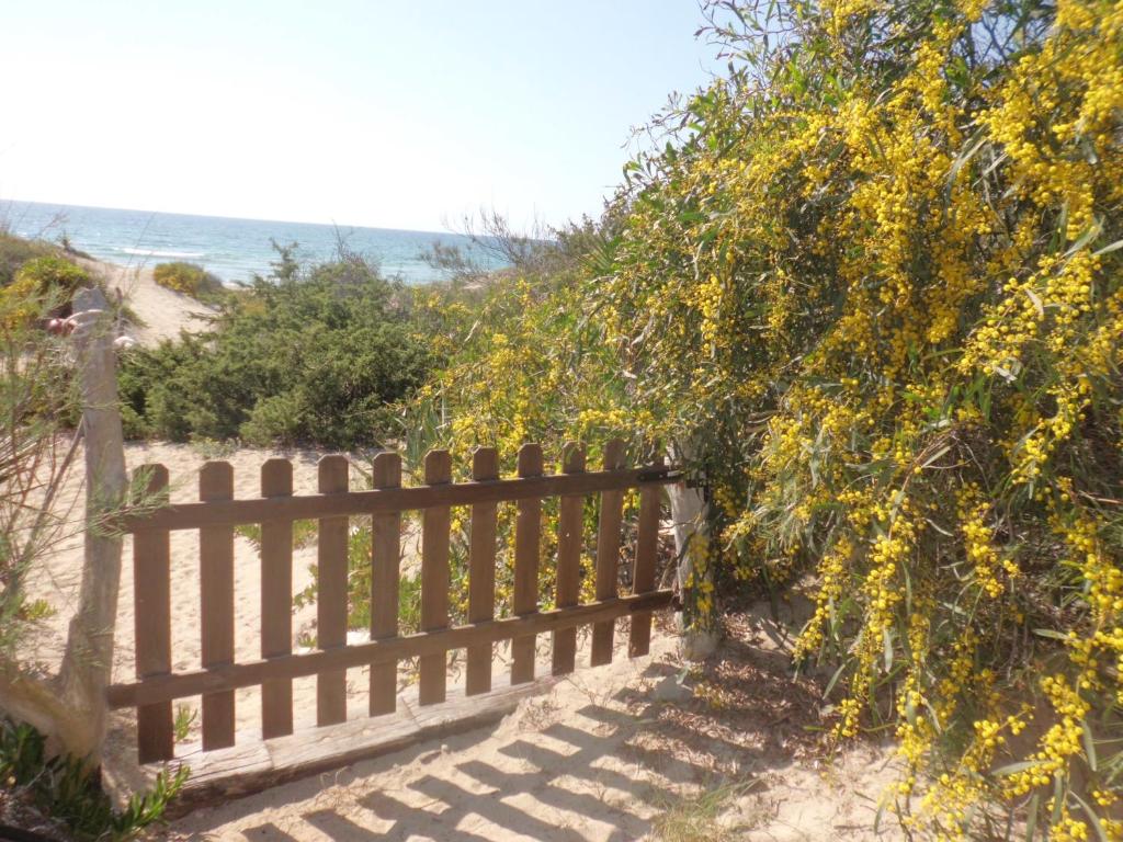 uma cerca de madeira ao lado de uma praia em Acacia sul mare em Gallipoli