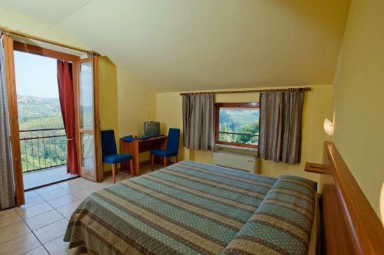 塞拉倫加達爾巴的住宿－Locanda Italia，卧室配有一张床、一张书桌和窗户。